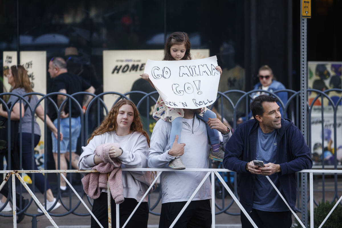 A young spectator holds up a sign as runners compete in the 10k and half-marathon along the Las ...