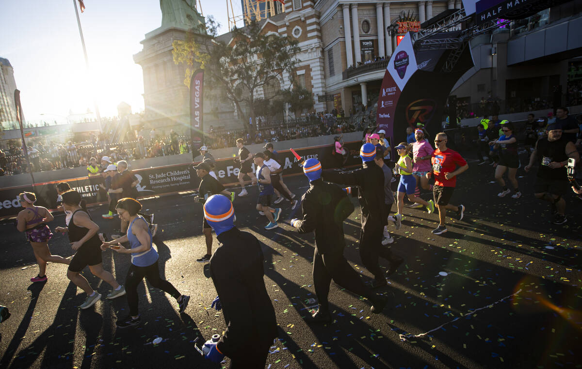 Members of the Blue Man Group interact with race participants as they take off from the start l ...