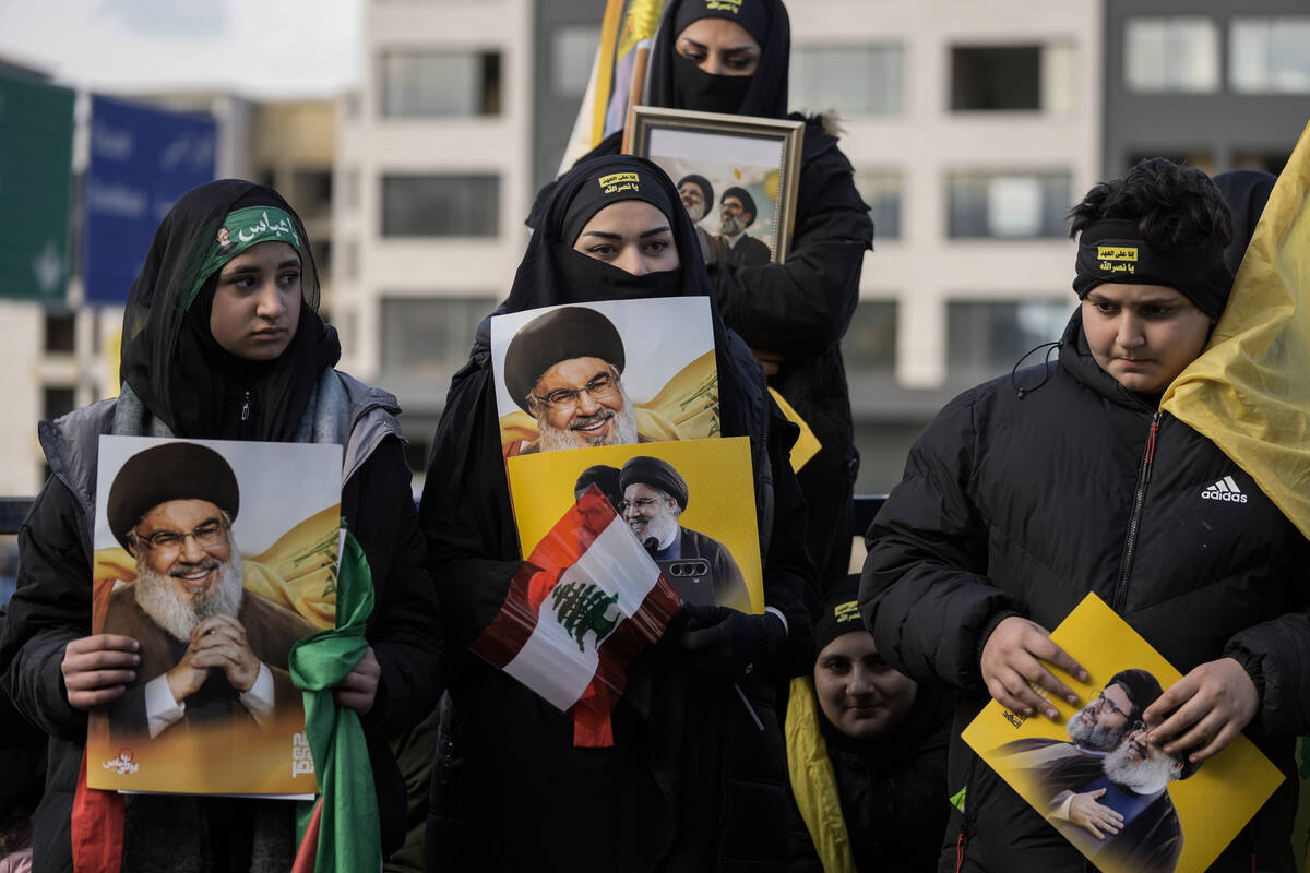 Mourners hold pictures of Lebanon's former Hezbollah leaders, Hassan Nasrallah and Hashem Safie ...