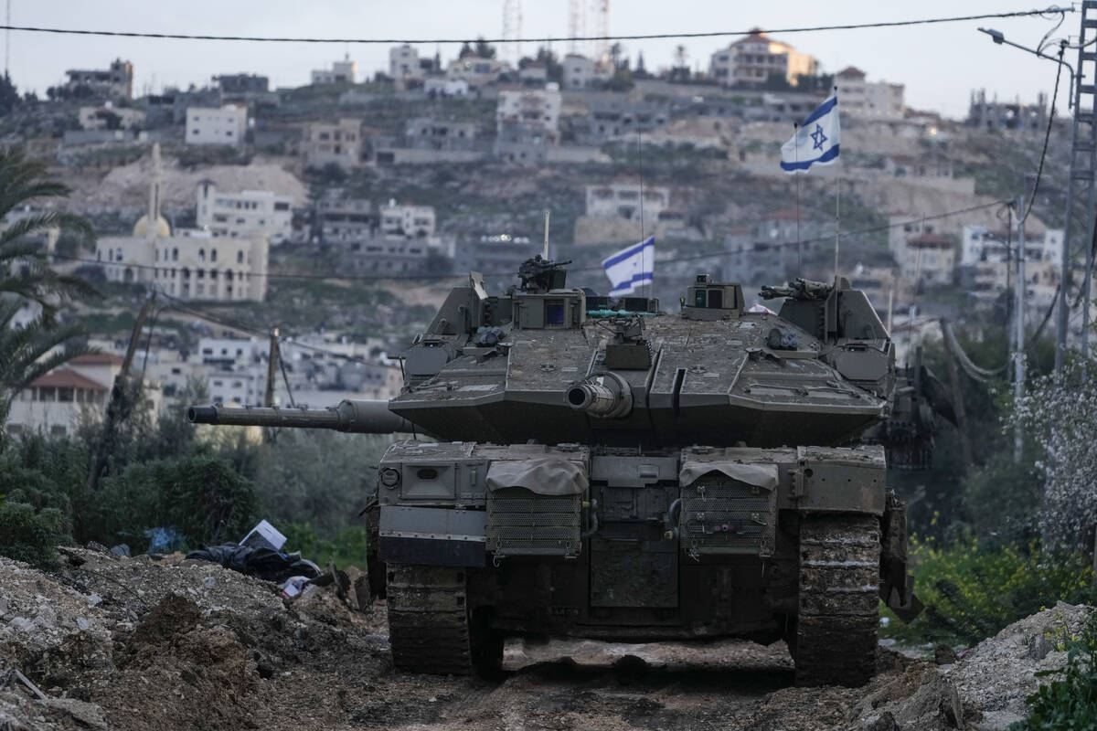An Israeli tank drives towards the occupied West Bank of Jenin camp, Sunday, Feb. 23, 2025. (AP ...