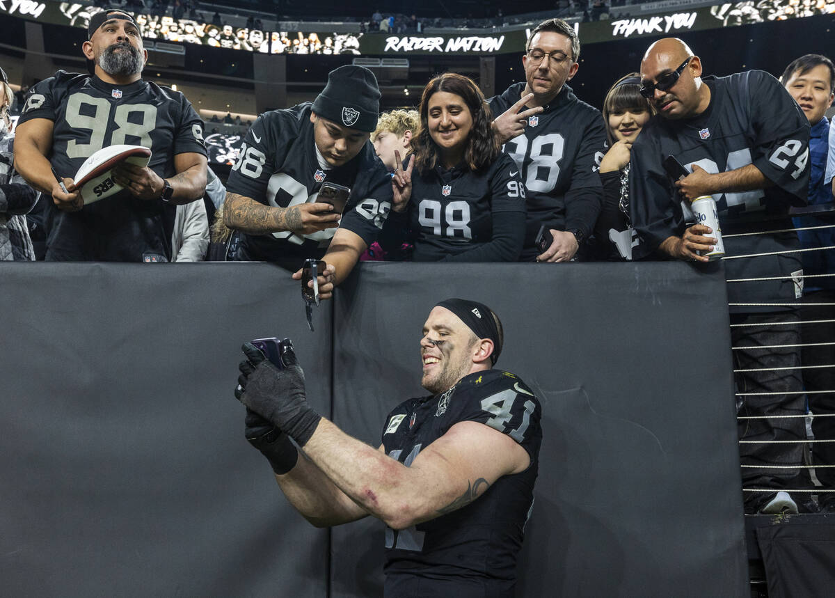 Raiders linebacker Robert Spillane (41) takes a selfie with fan after their loss to Los Angeles ...