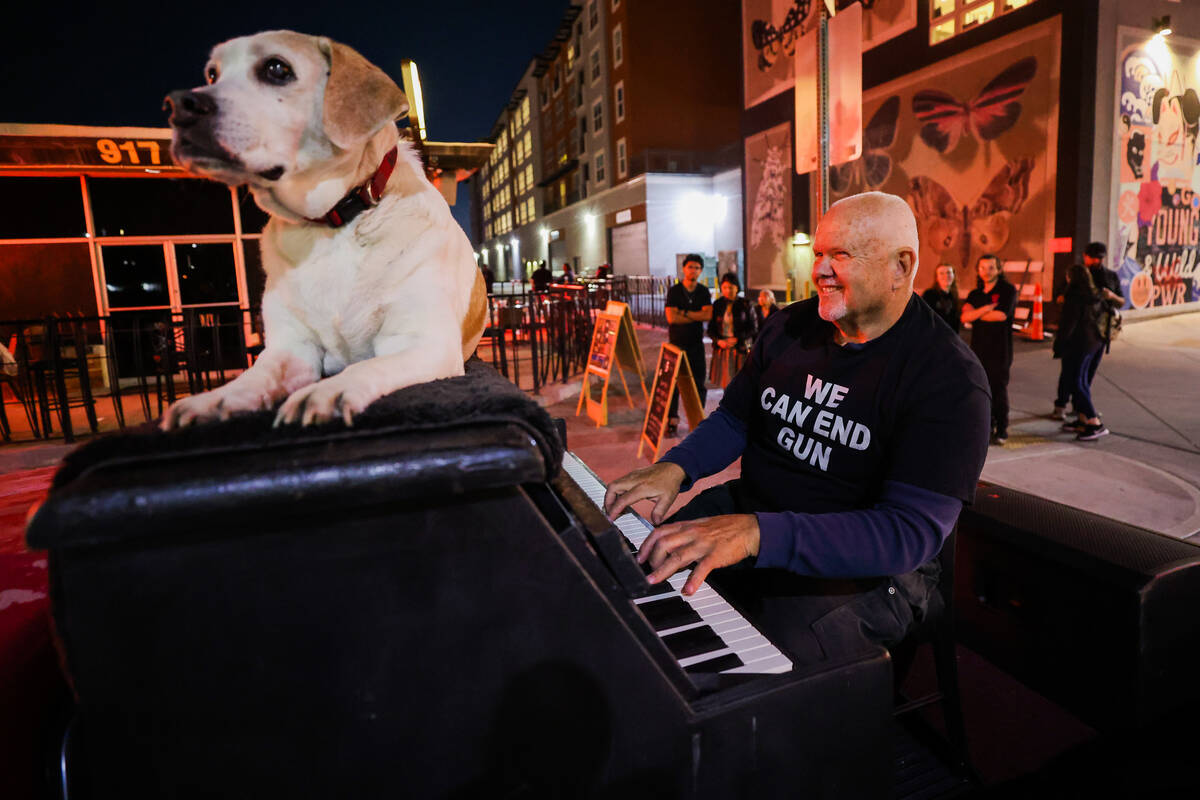 Danny Kean plays the piano with his dog, Mo, on top of it to raise money during a fundraiser i ...