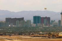 A jet begins an approach for landing at Nellis Air Force Base with the skyline beyond it on Fri ...