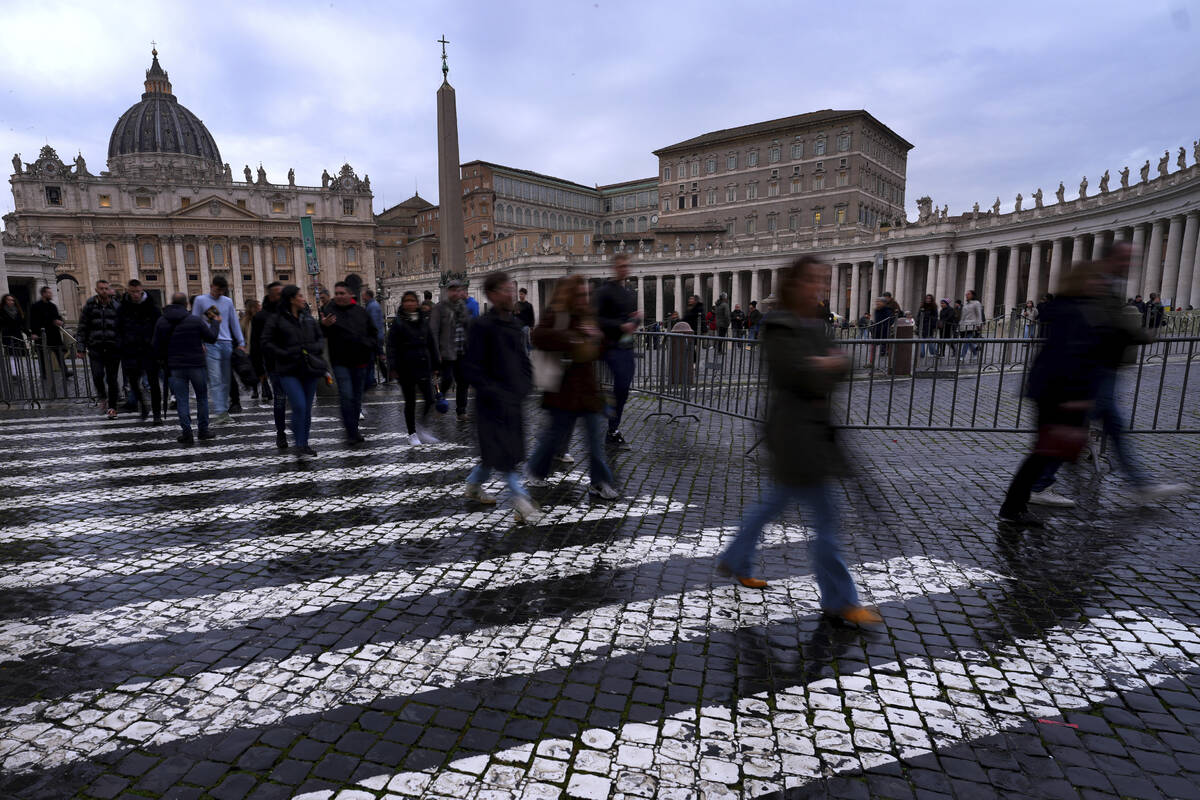 People walk outside St. Peter's Square at The Vatican, Monday, Feb. 24, 2025. (AP Photo/Kirsty ...