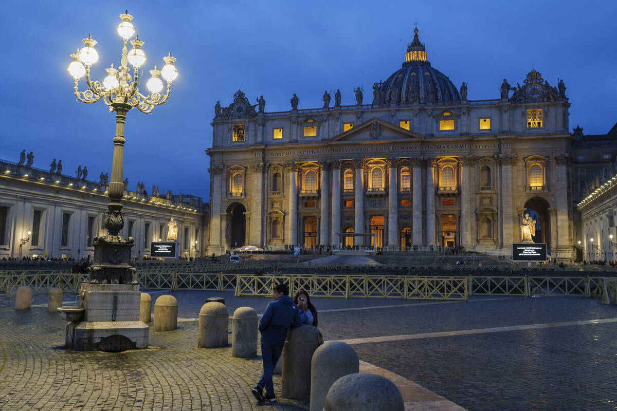 A couple stands in St. Peter's Square at The Vatican, Monday, Feb. 24, 2025. (AP Photo/Bernat A ...