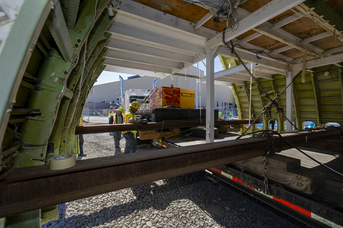 A decommissioned 747 fuselage section is unstrapped while placed amongst other parts after bein ...