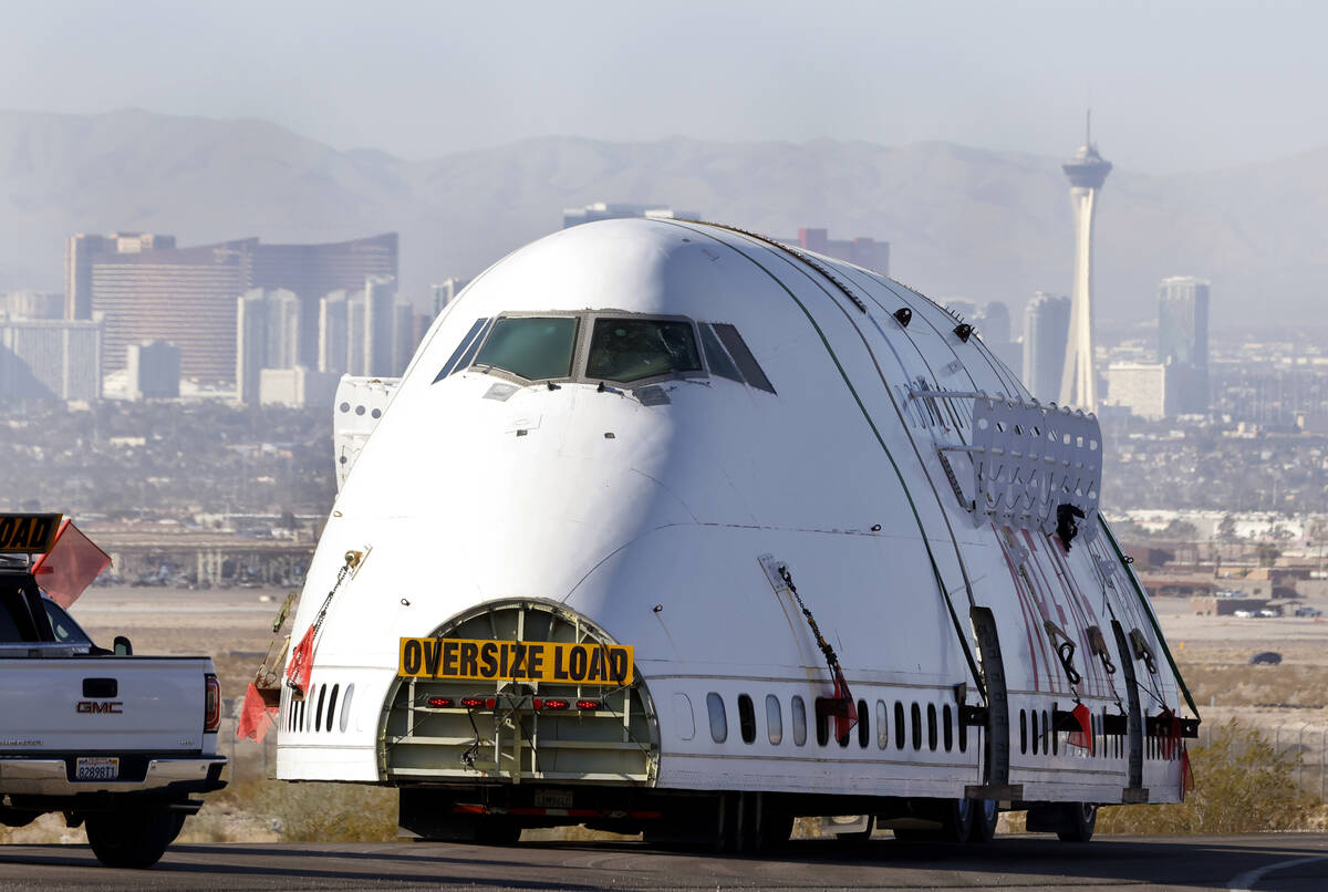 A decommissioned 747 fuselage is escorted as it departs from the Las Vegas Speedway on North La ...