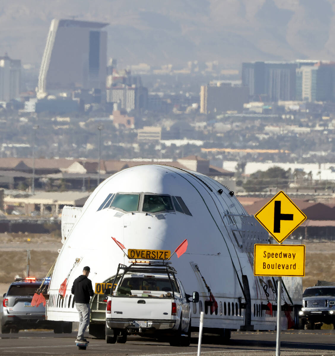 A decommissioned 747 fuselage is escorted as it departs from the Las Vegas Speedway on North La ...