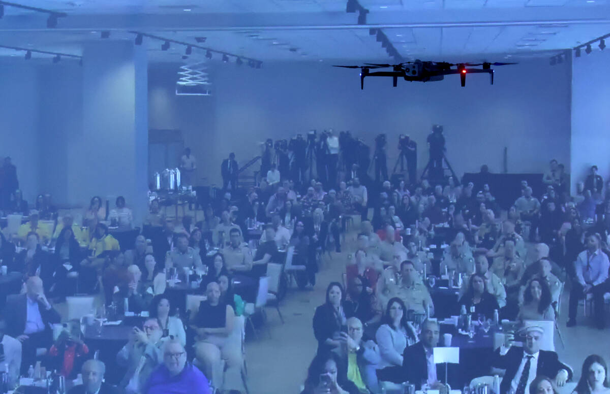 Guests are projected on a screen using a drone camera during Clark County Sheriff Kevin McMahil ...