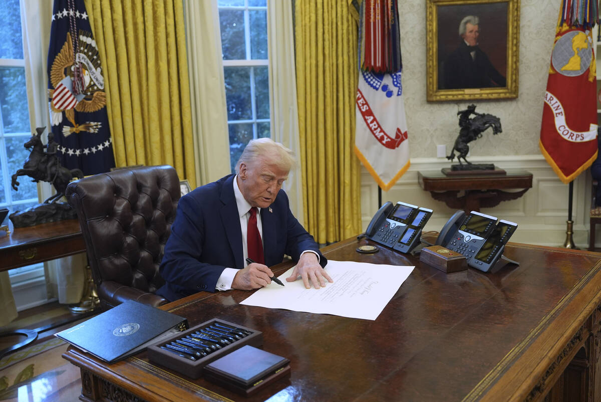 President Donald Trump signs executive orders in the Oval Office at the White House, Thursday, ...