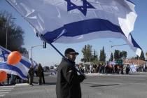 Israelis gather on the side of a road where the funeral convoy carrying the coffins of slain ho ...