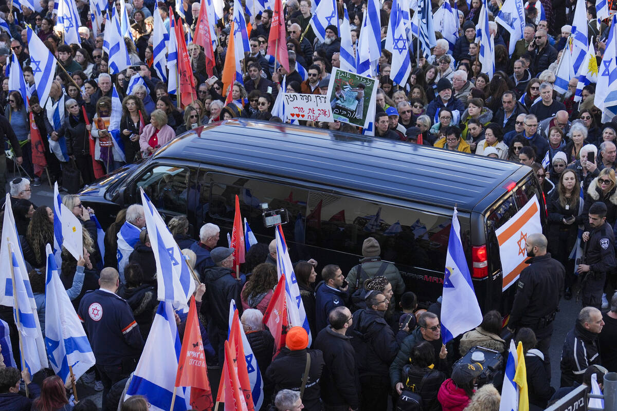 Mourners gather around the convoy carrying the coffins of slain hostages Shiri Bibas and her tw ...