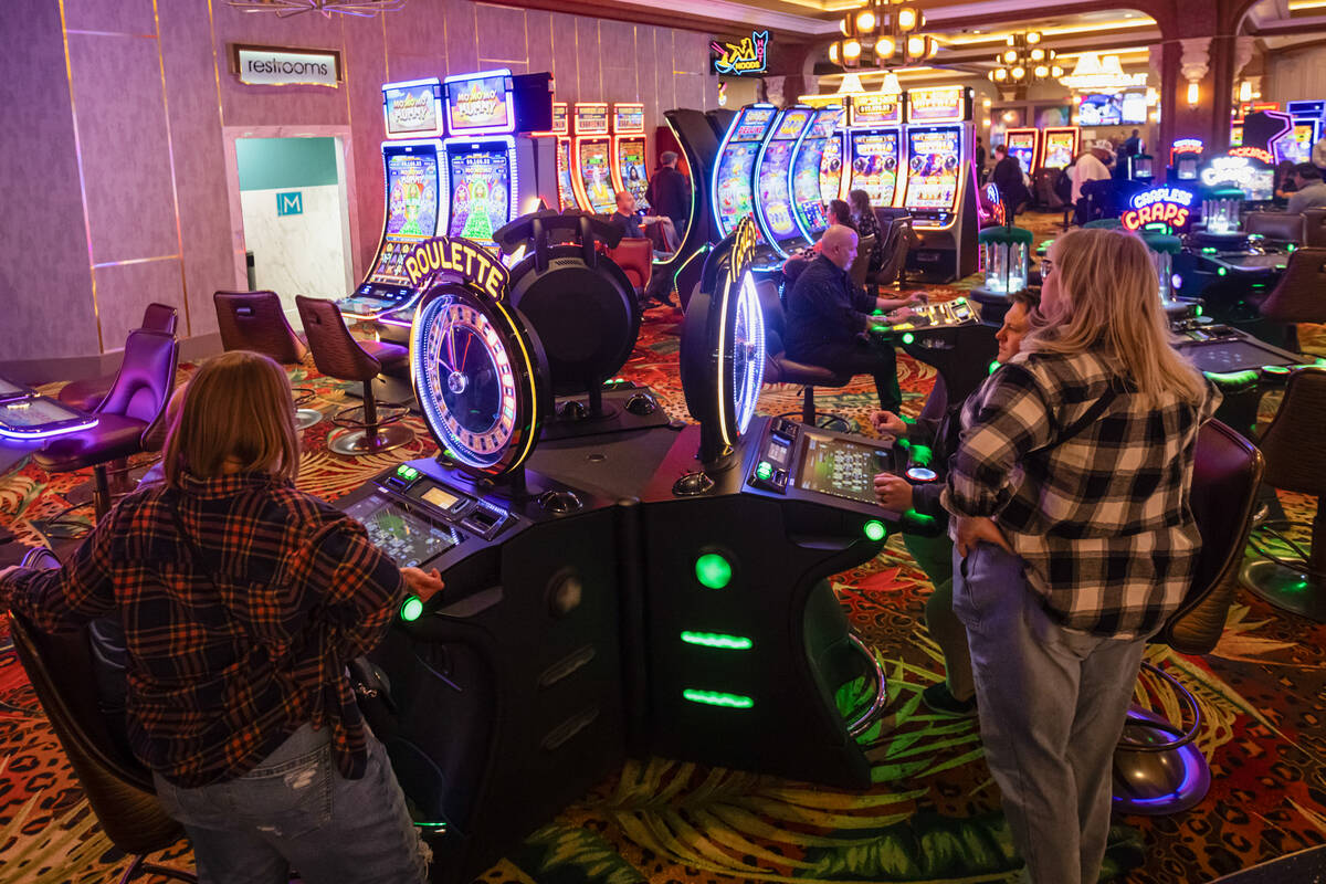 People play on gaming machines following the opening celebration for the newly expanded casino ...