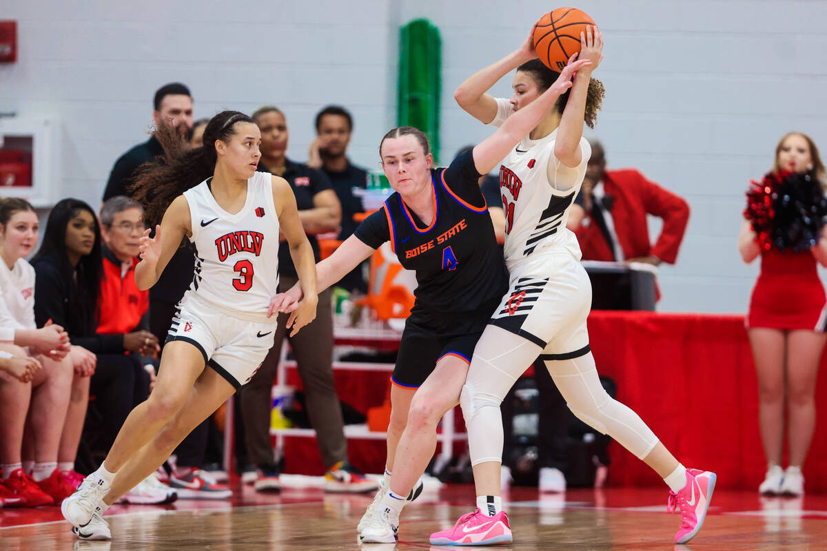 Lady Rebels forward McKinna Brackens (21) tries to pass the ball to Lady Rebels guard Kiara Jac ...