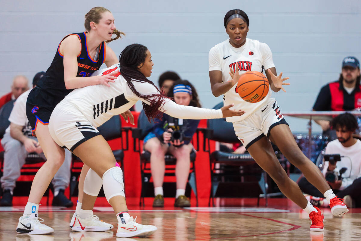 Lady Rebels forward Alyssa Brown (44) passes the ball to Lady Rebels forward Macie James (20) d ...