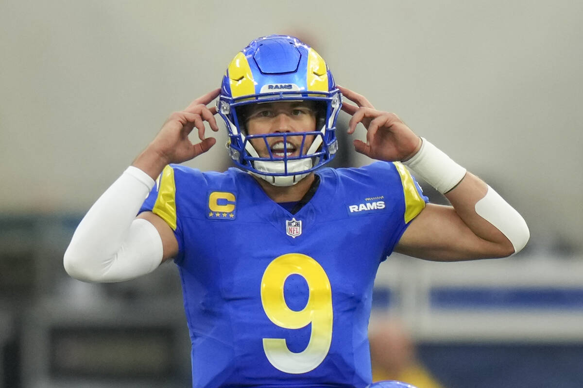Los Angeles Rams quarterback Matthew Stafford talks to his teammates before running a play agai ...
