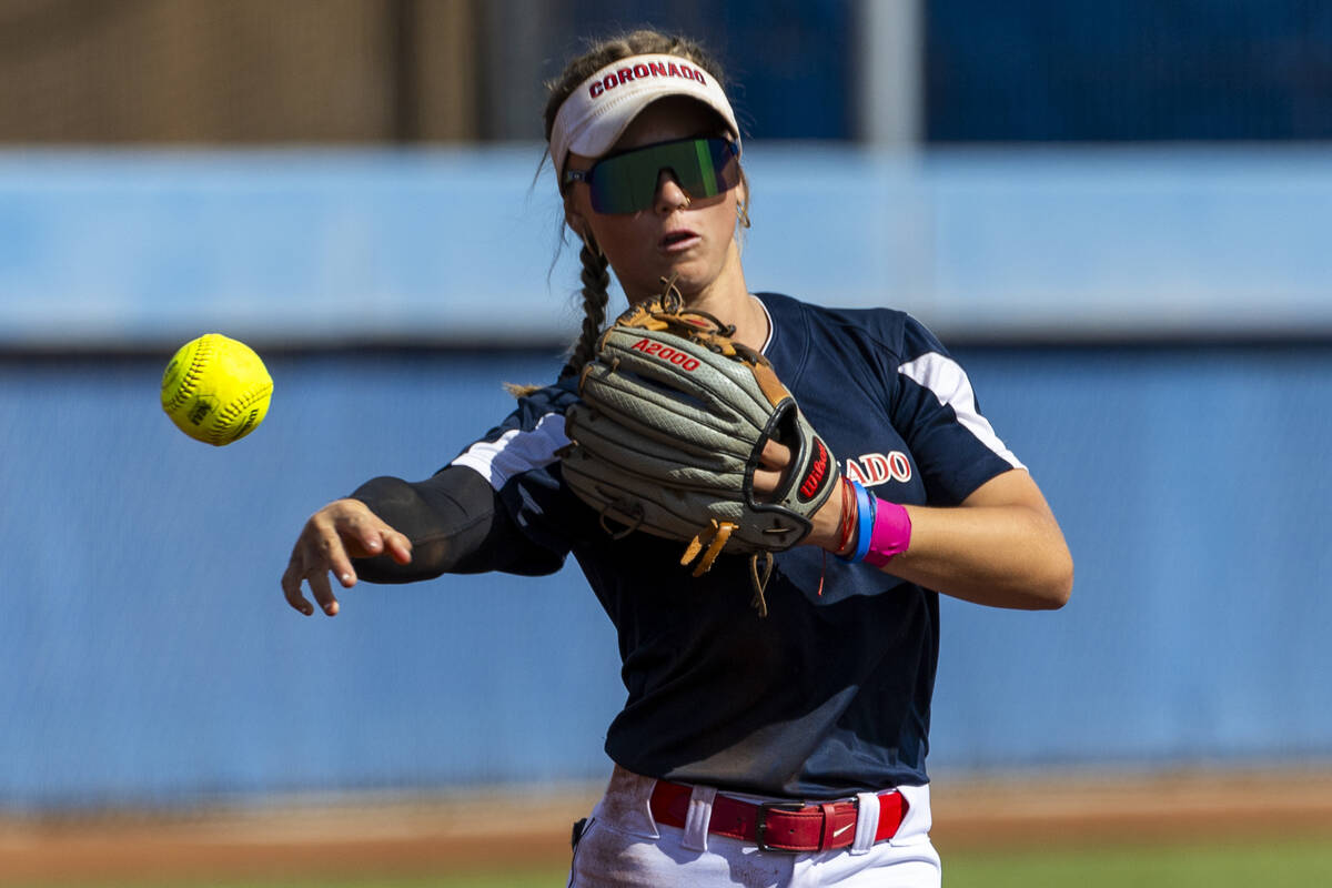 Coronado runner Bailey Goldberg (1) tosses the ball to first base against a Douglas runner duri ...