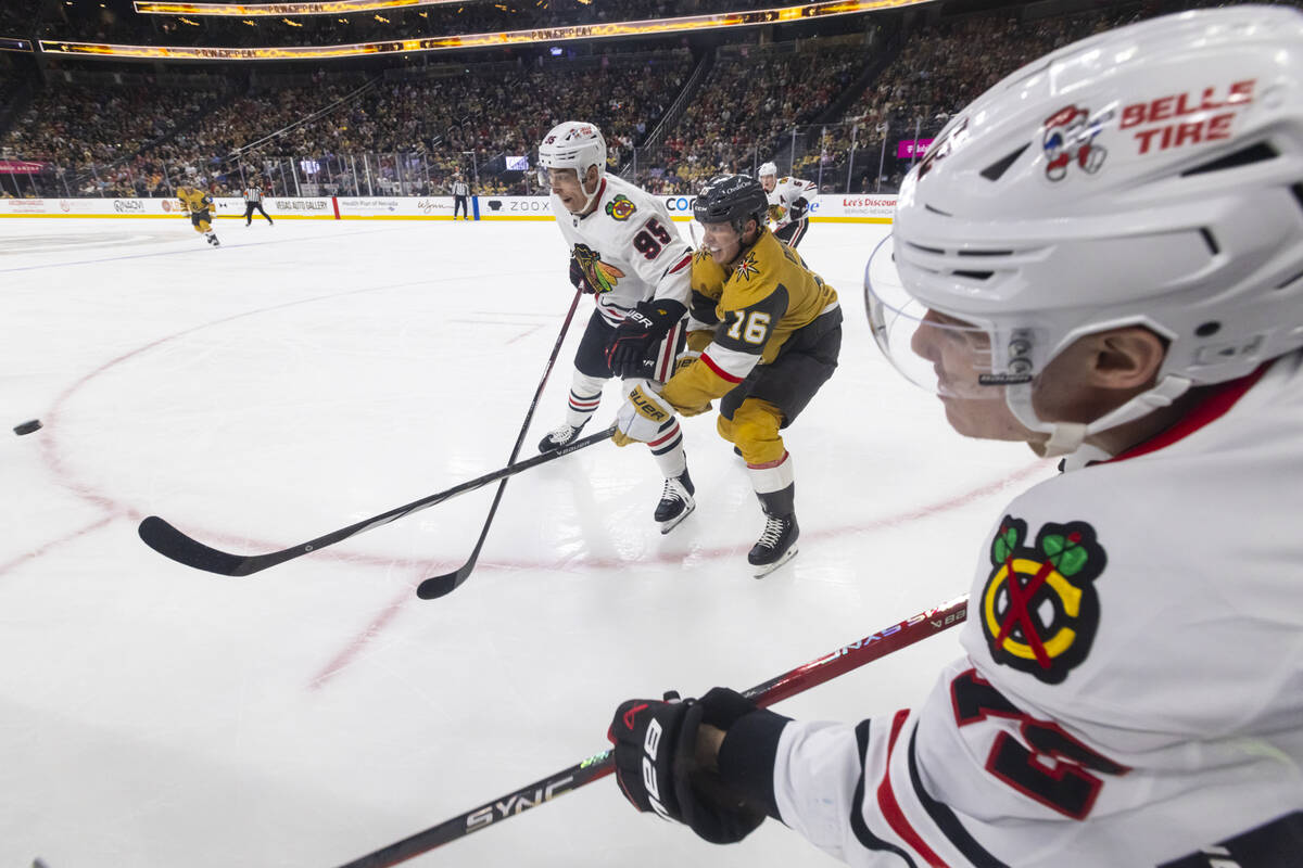 Chicago Blackhawks defenseman Alex Vlasic, right, chases after the puck along with right wing I ...