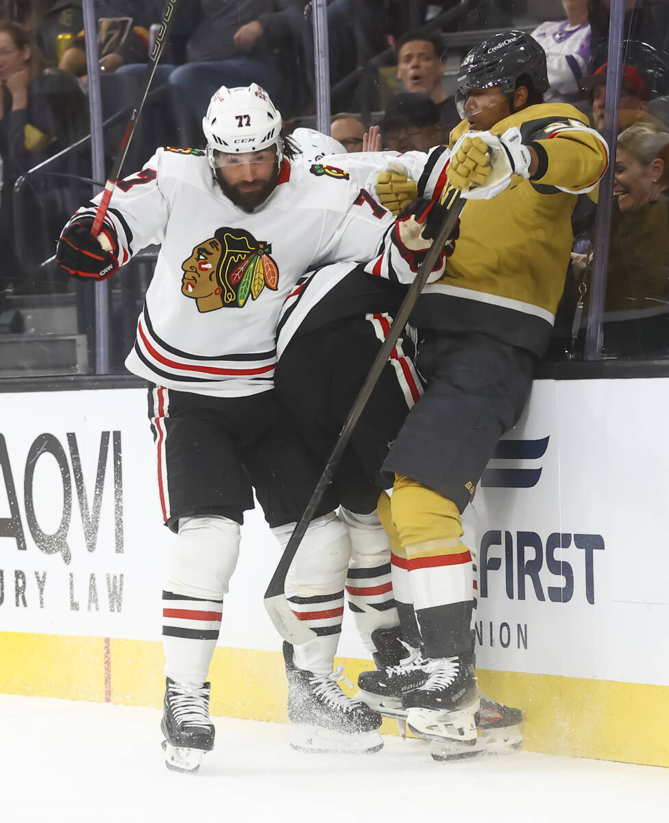 Golden Knights right wing Keegan Kolesar (55) gets slammed against the glass by Chicago Blackha ...