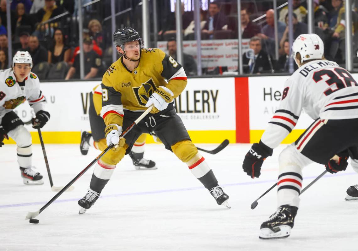 Golden Knights center Jack Eichel (9) looks to get the puck around Chicago Blackhawks defensema ...