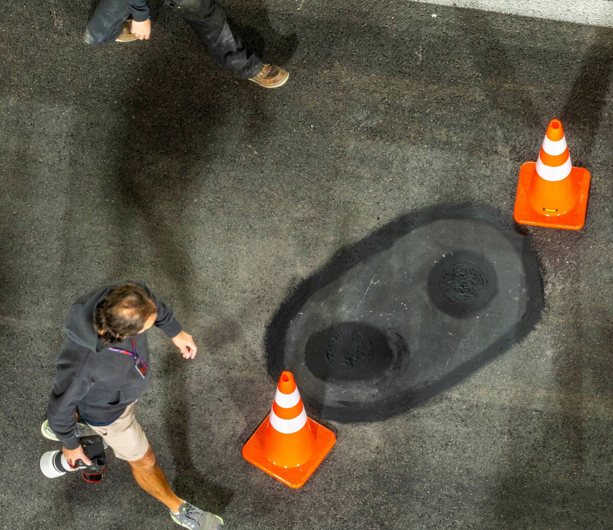 One of the valve covers secured and the pavement around smoothed by a crew from Las Vegas Pavin ...