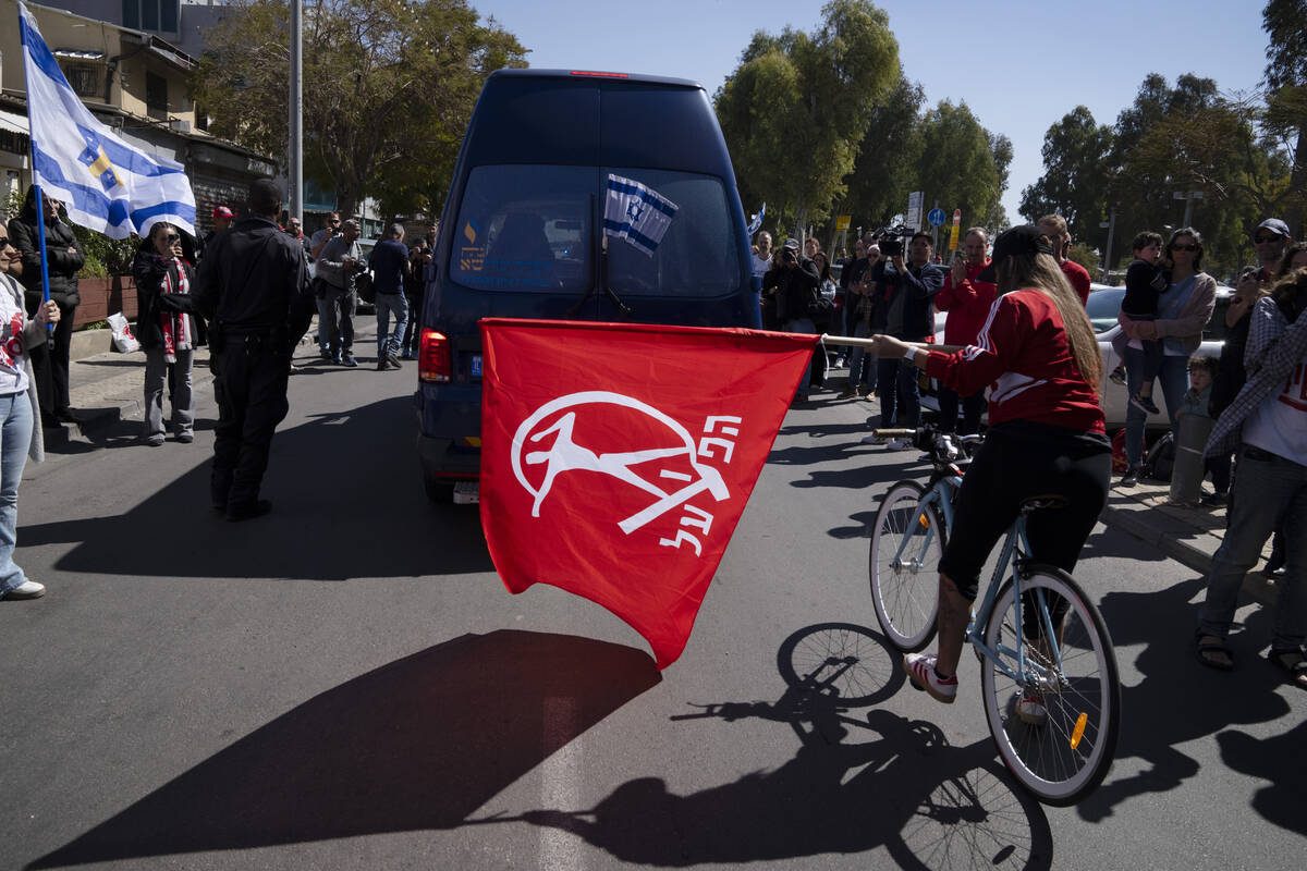 People attend a public memorial ceremony for slain hostage Tsachi Idan, a fan of Hapoel Tel Avi ...