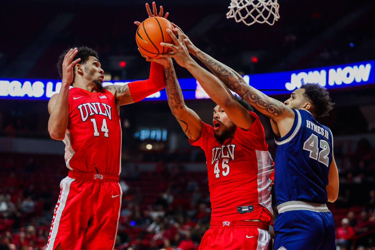 Rebels forward Jeremiah Cherry (45) and Rebels guard Jailen Bedford (14) try to recover a ball ...