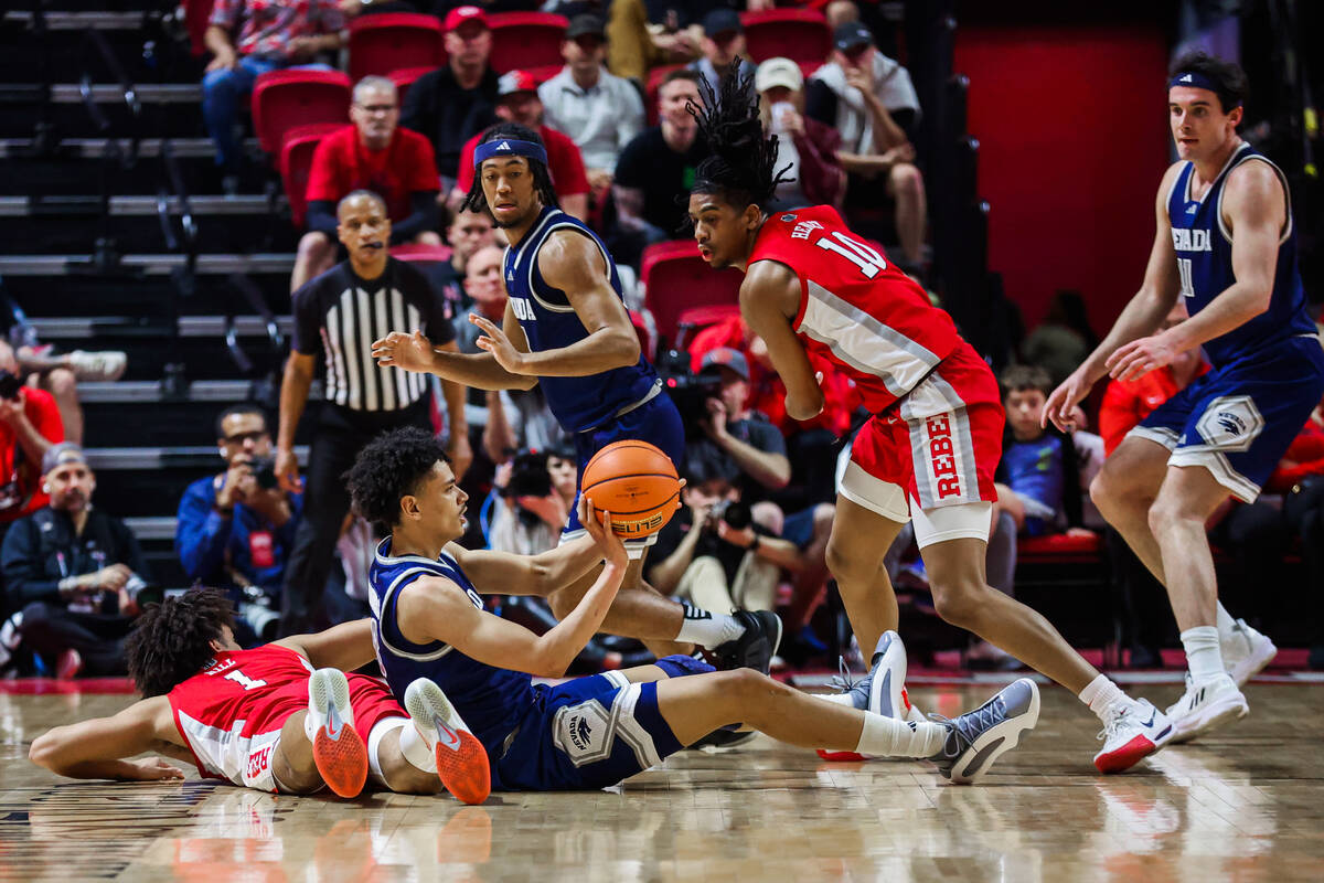 Rebels forward Jalen Hill (1) falls after getting into it with UNR Wolf Pack guard Kobe Sanders ...