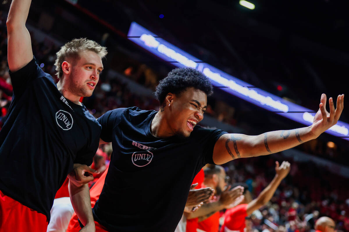 Rebels guard Jace Whiting, left, and forward Rob Whaley Jr. cheer for their teammates from the ...