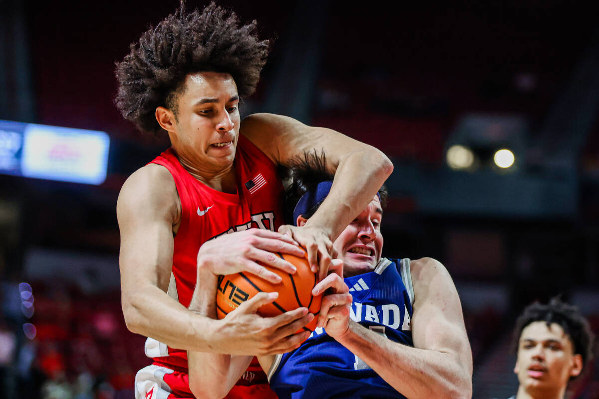 UNR Wolf Pack forward Nick Davidson (11) and Rebels forward Jalen Hill (1) struggle over posses ...