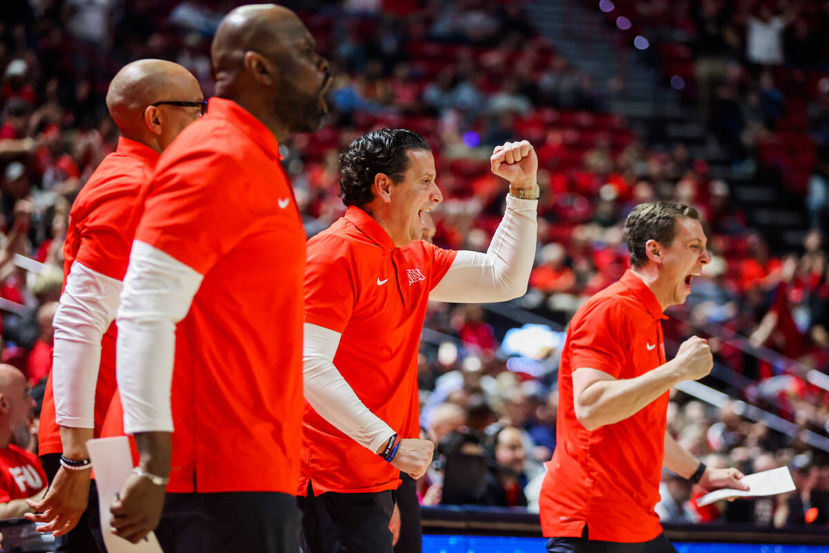 Rebels catching staff cheers for their team during an NCAA men’s basketball game between ...