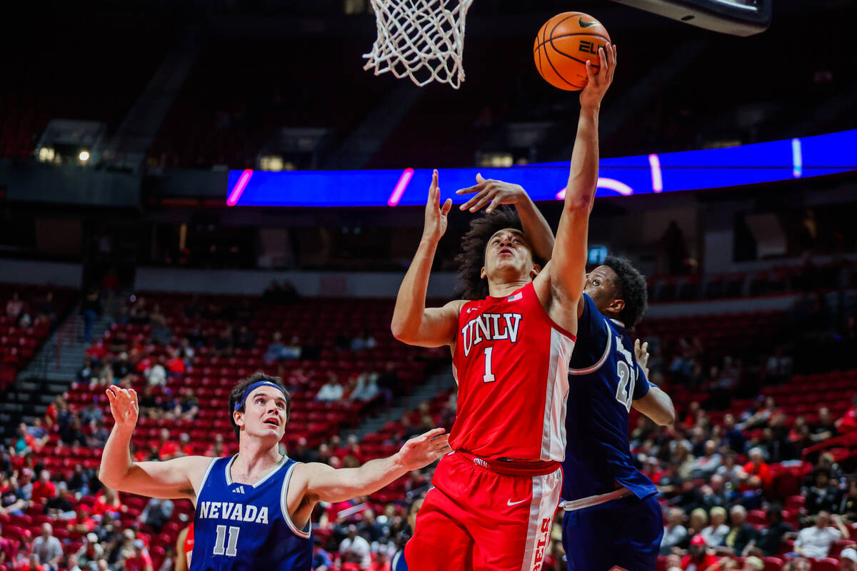 UNR Wolf Pack forward Justin McBride (21) blocks Rebels forward Jalen Hill (1) as he goes up fo ...