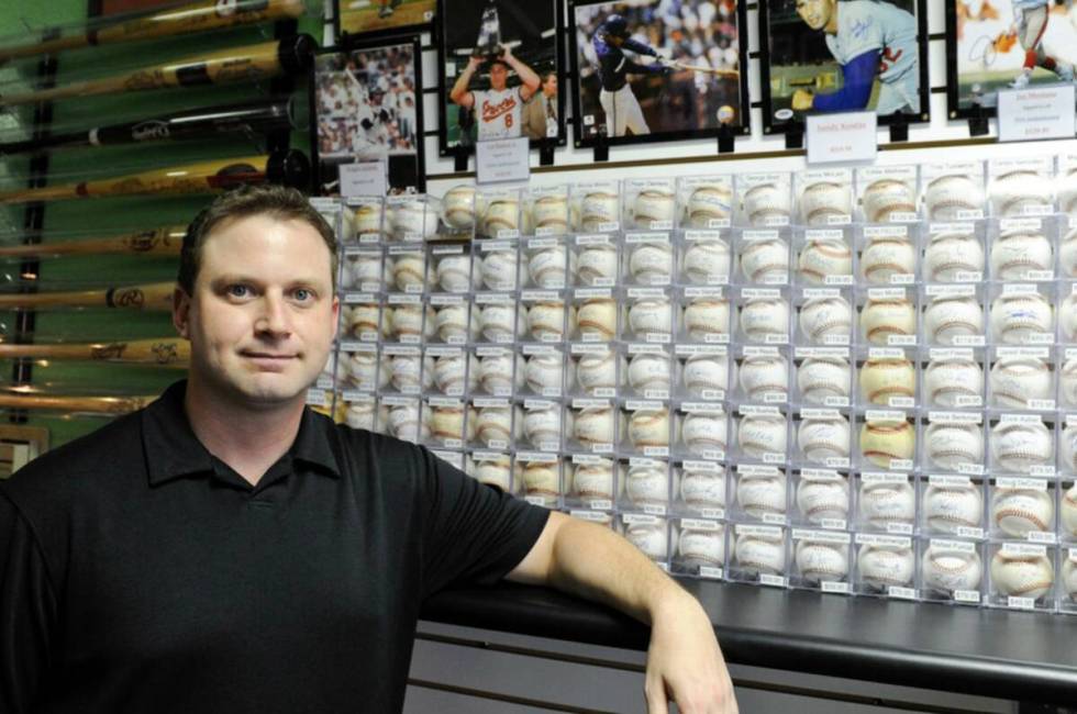 Jeremy Brown, owner of Ultimate Sports Cards & Memorabilia, poses for a portrait inside his sto ...