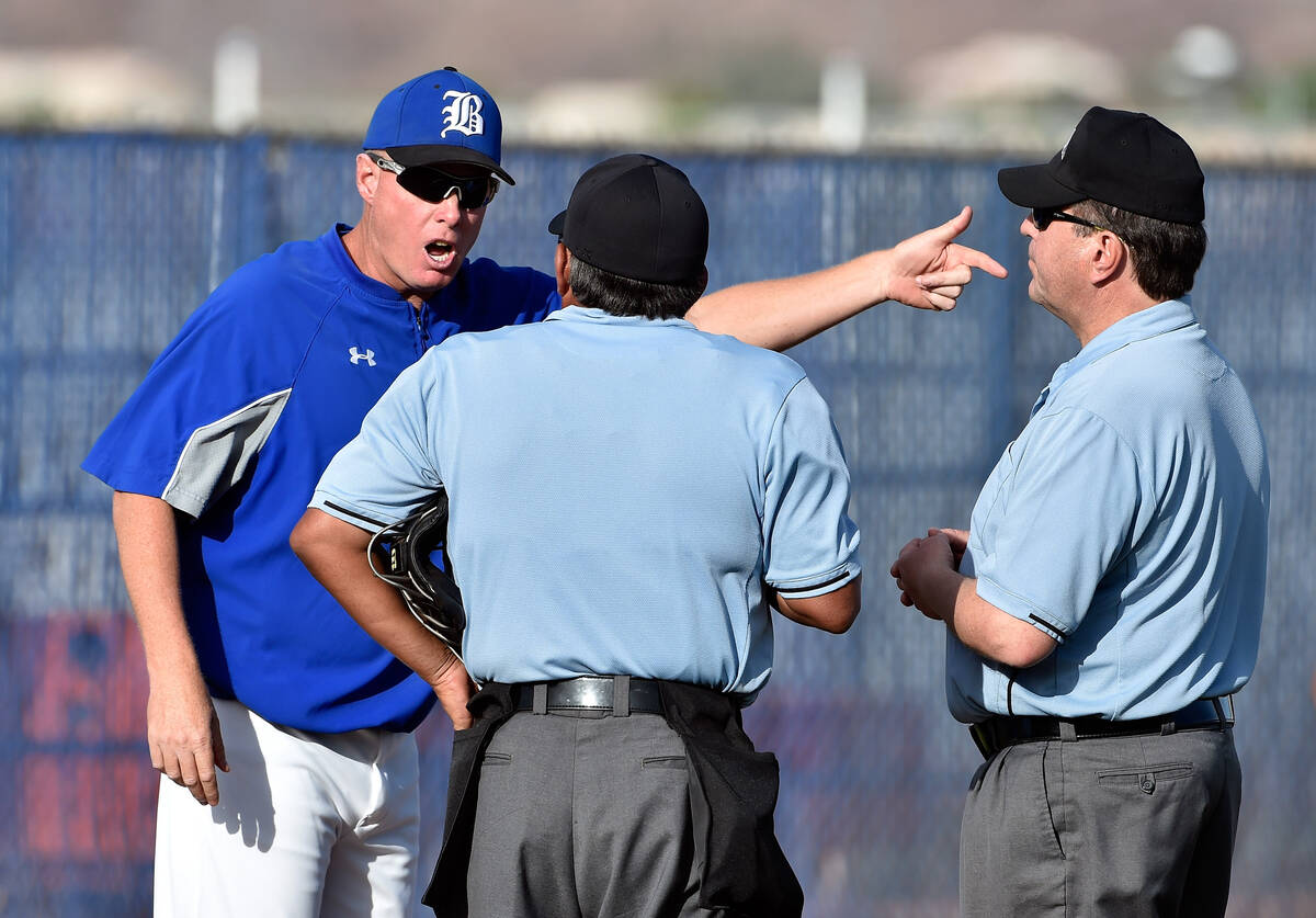 Basic head coach Scott Baker, left, questions the umpire's call during a high school baseball g ...