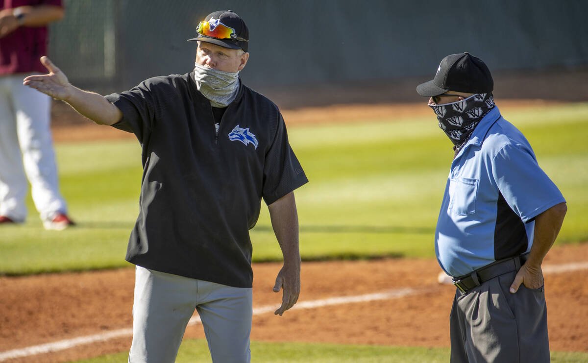 Basic High School head coach Scott Baker argues an out with the umpire versus Desert Oasis ...