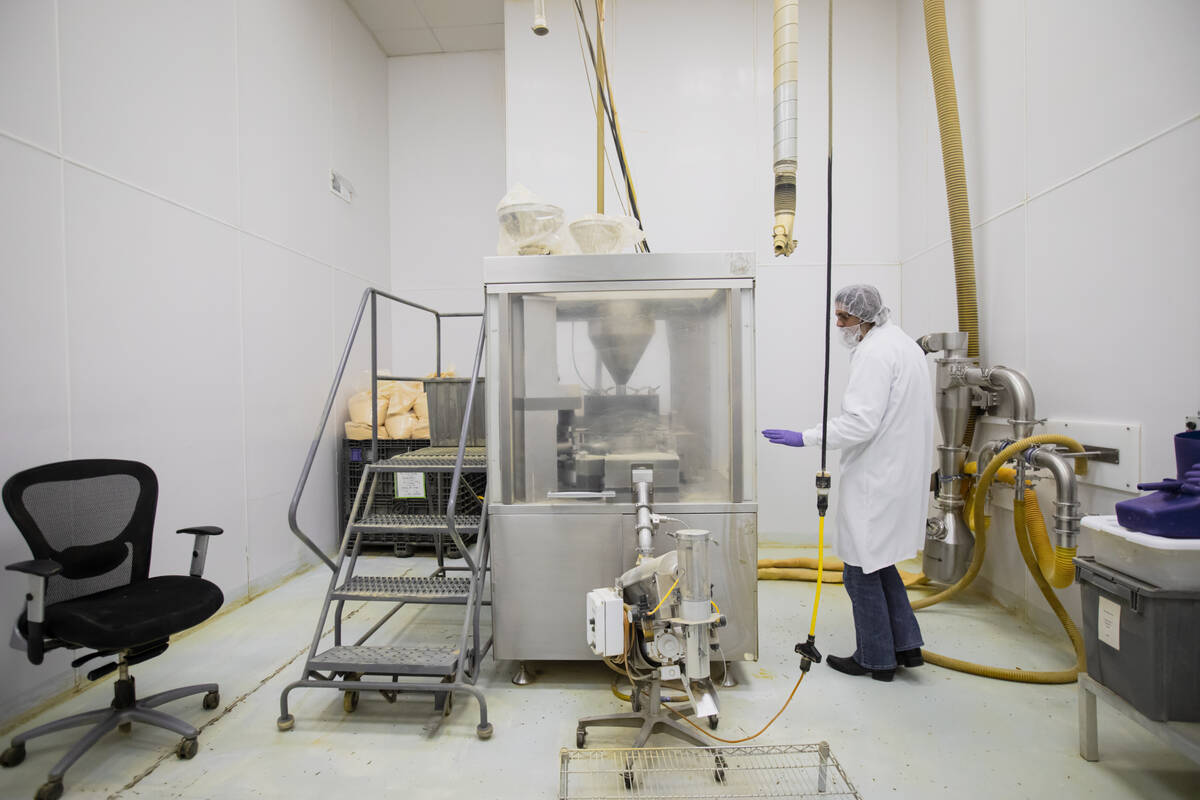 James Smith, VP of operations at DrVita, shows a machine that presses together capsules for sup ...