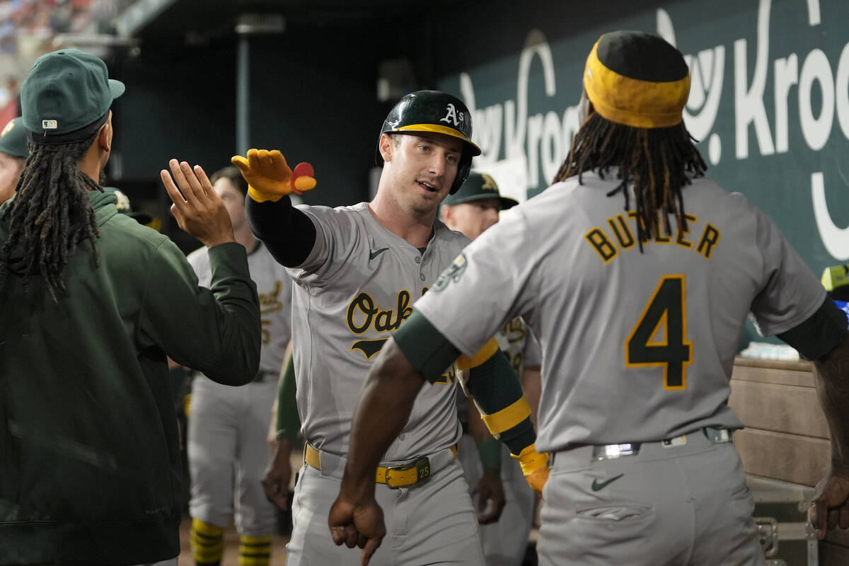 Oakland Athletics' Brent Rooker, center, and Lawrence Butler (4) celebrate after Rooker's solo ...