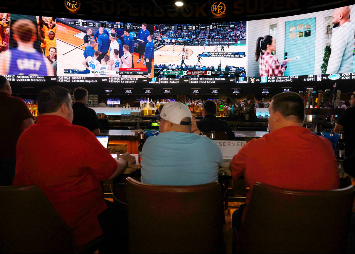 Guests watch on the big screens the first day of the NCAA basketball tournament at Westgate spo ...