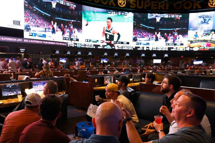 Guests watch on the big screens the first day of the NCAA basketball tournament at Westgate spo ...