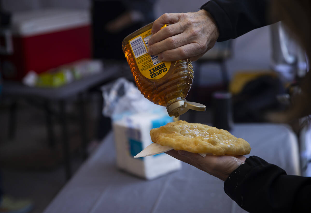 An attendee puts honey on their fry bread during the Winter Gathering at the Red Rock Canyon Na ...
