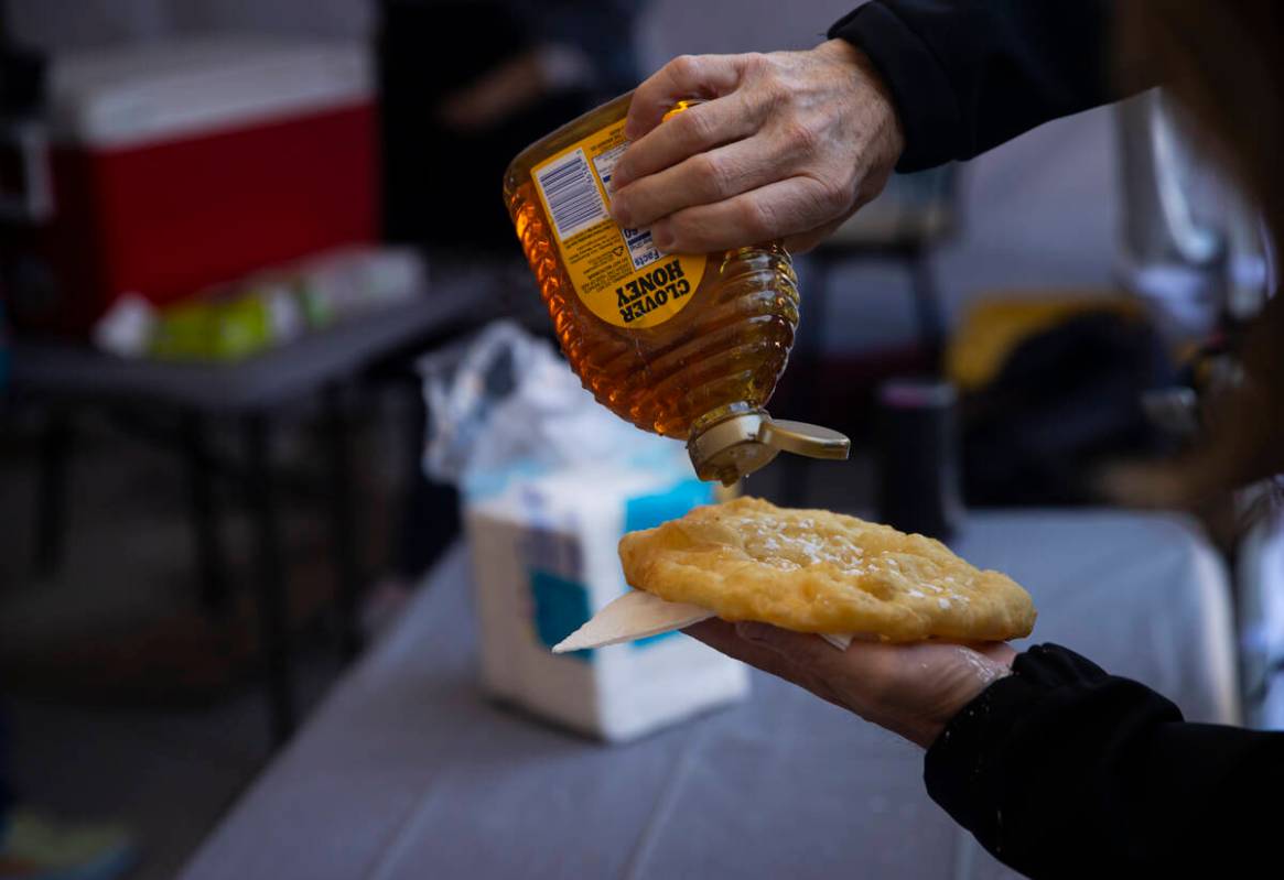 An attendee puts honey on their fry bread during the Winter Gathering at the Red Rock Canyon Na ...