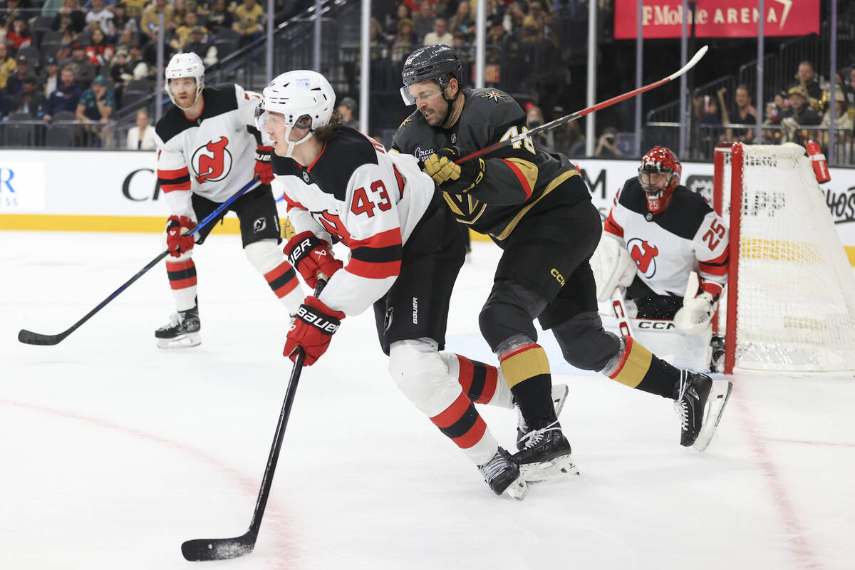 Vegas Golden Knights center Tomas Hertl (48) pushes New Jersey Devils defenseman Luke Hughes (4 ...