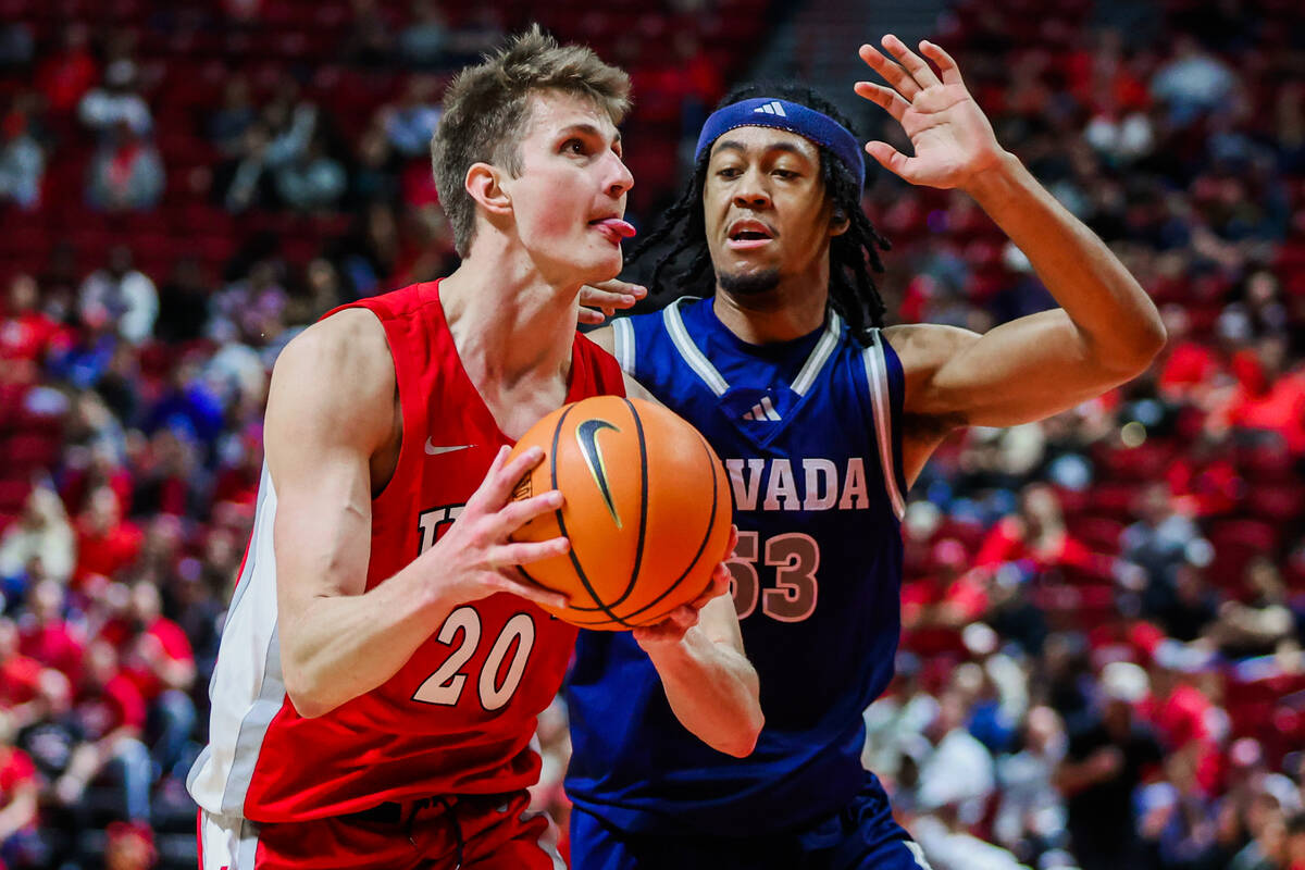 Rebels guard Julian Rishwain (20) sticks his tongue out as he eyes the hoop while UNR Wolf Pack ...