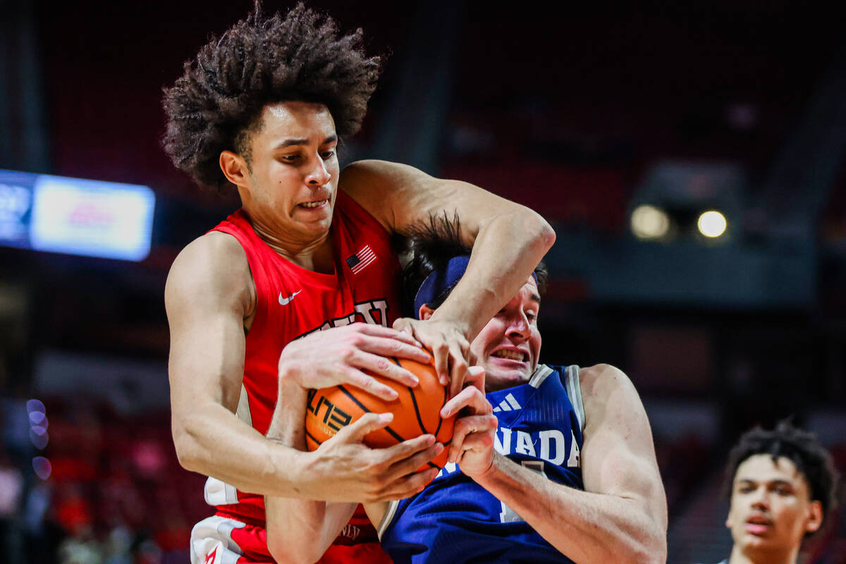 UNR Wolf Pack forward Nick Davidson (11) and Rebels forward Jalen Hill (1) struggle over posses ...