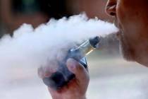 A man exhales while smoking an e-cigarette in Portland, Maine. (AP Photo/Robert F. Bukaty, File)
