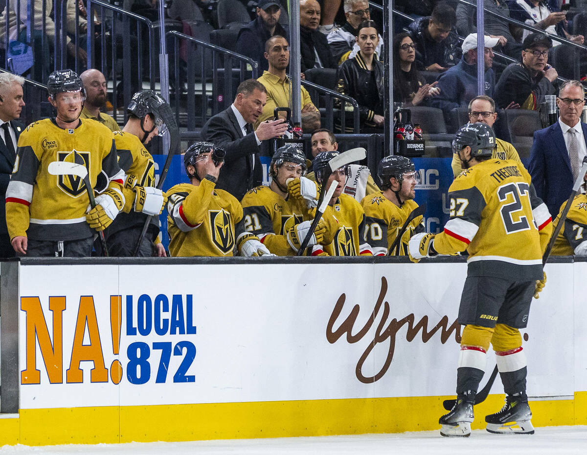 Golden Knights head coach Bruce Cassidy talks with defenseman Shea Theodore (27) during a timeo ...