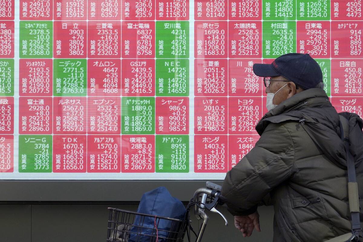 A person looks at an electronic stock board showing Japan's Nikkei index at a securities firm T ...