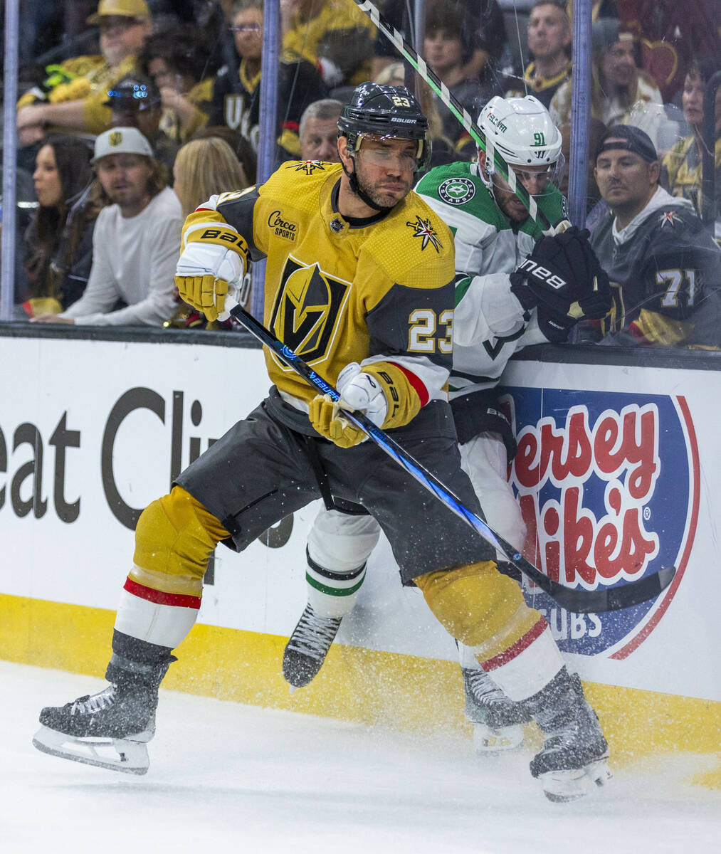 Golden Knights defenseman Alec Martinez (23) crashes into Dallas Stars center Tyler Seguin (91) ...