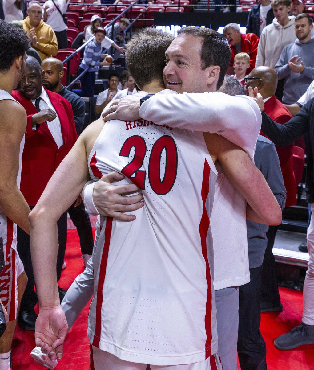 UNLV head coach Kevin Kruger hugs UNLV guard Julian Rishwain (20) after a big night against the ...