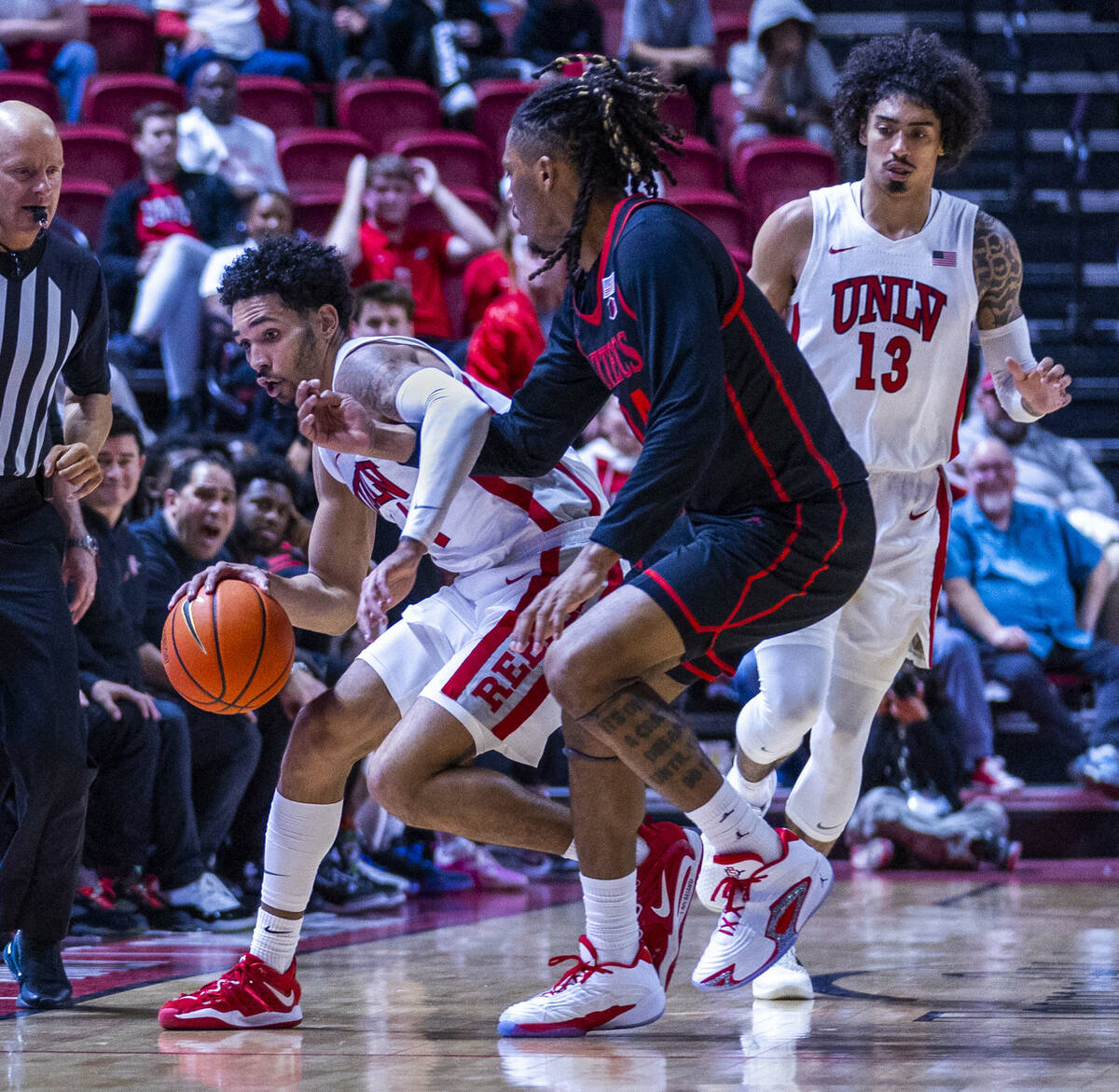 UNLV guard Jailen Bedford (14) is hgooked under the arm by San Diego State Aztecs guard Taj DeG ...